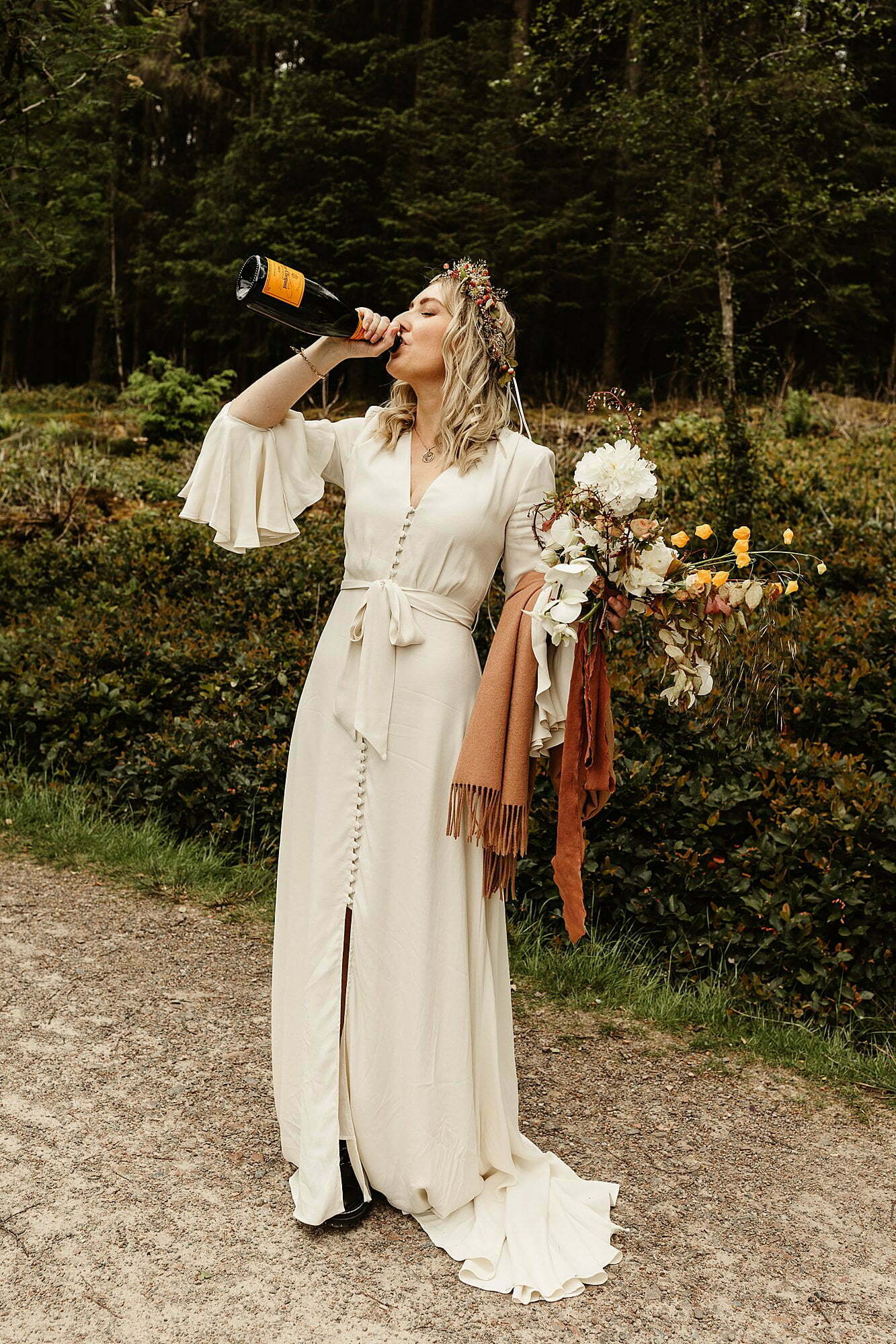 bride drinking veuve clicquot champagne from the bottle ghost fashion wedding dress wild flower workshop bouquet