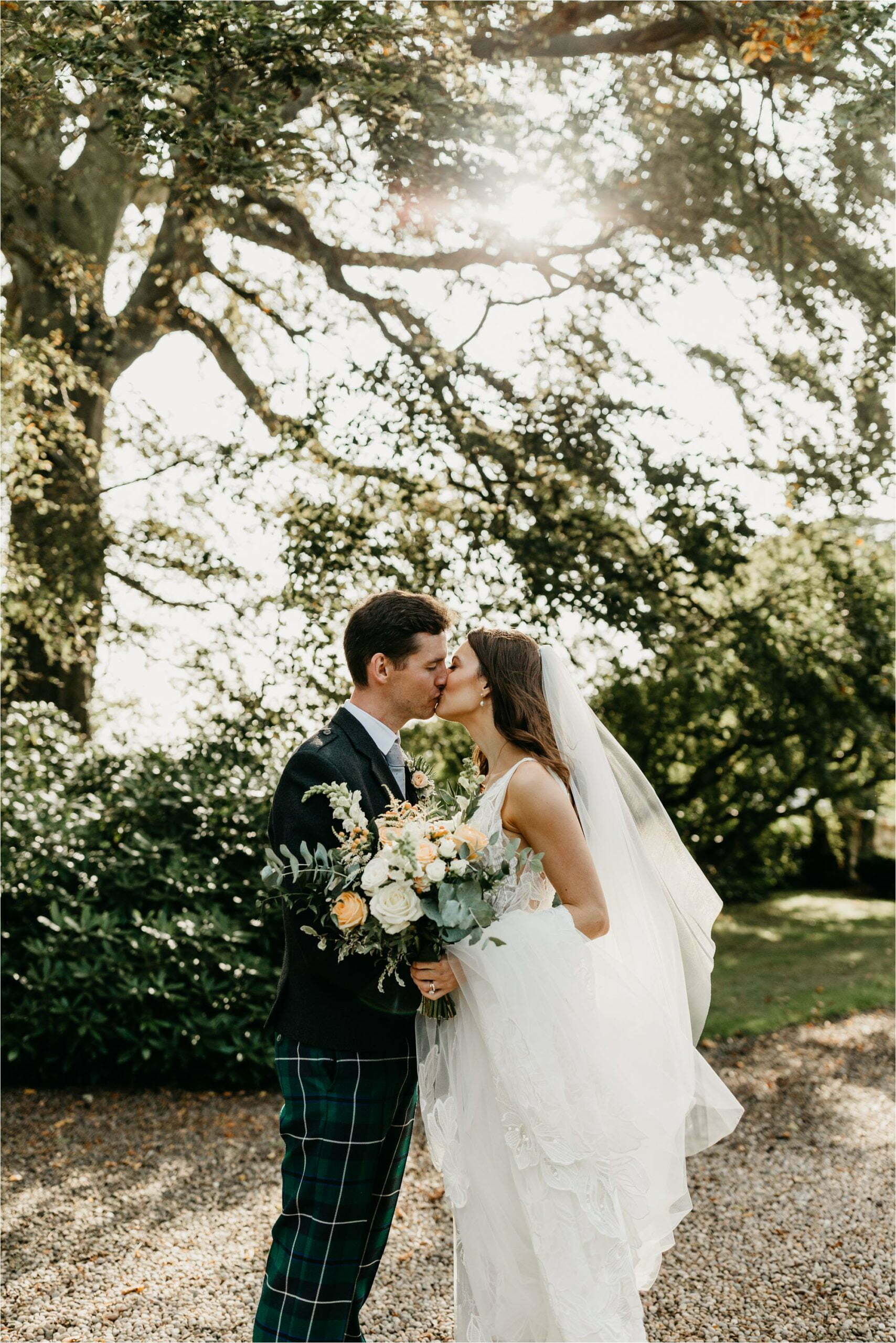 farm micro wedding scottish borders bride groom kissing with sun flare