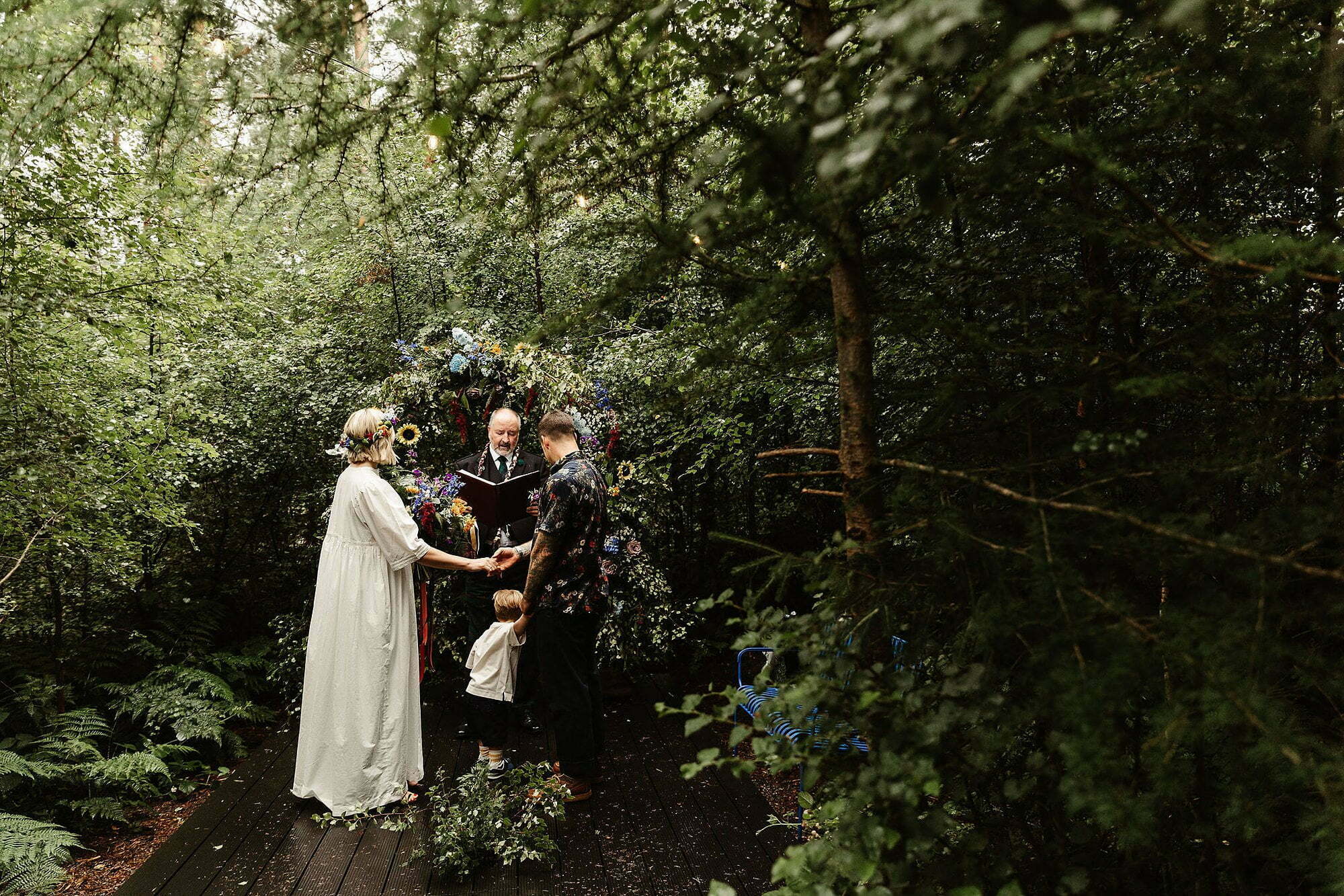 Bride groom outdoor woodland humanist wedding ceremony colourful flower arch glen dye