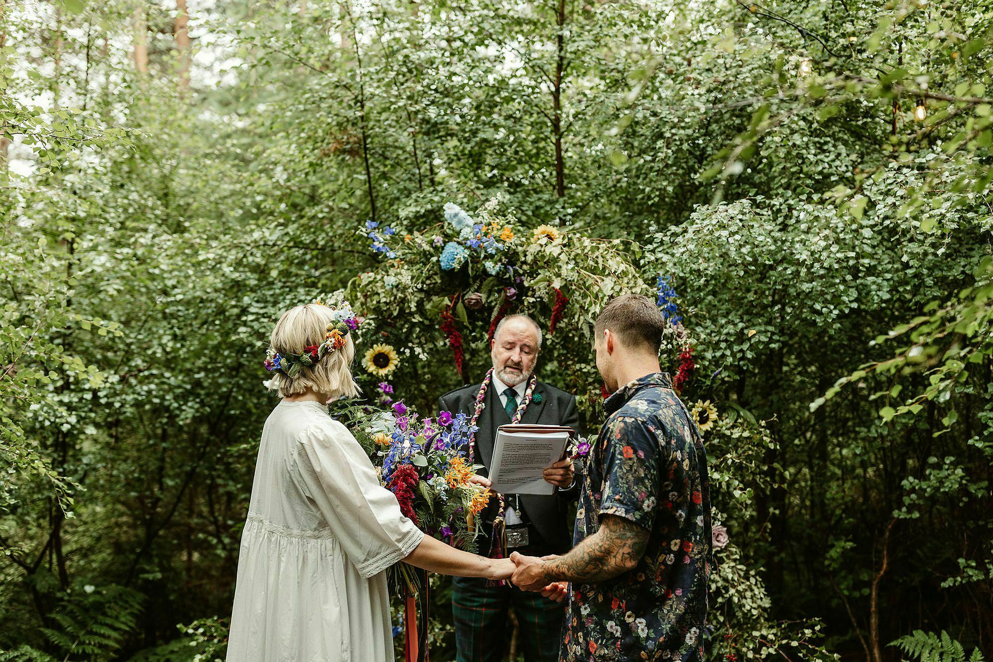 Bride groom outdoor woodland humanist wedding ceremony colourful flower arch glen dye