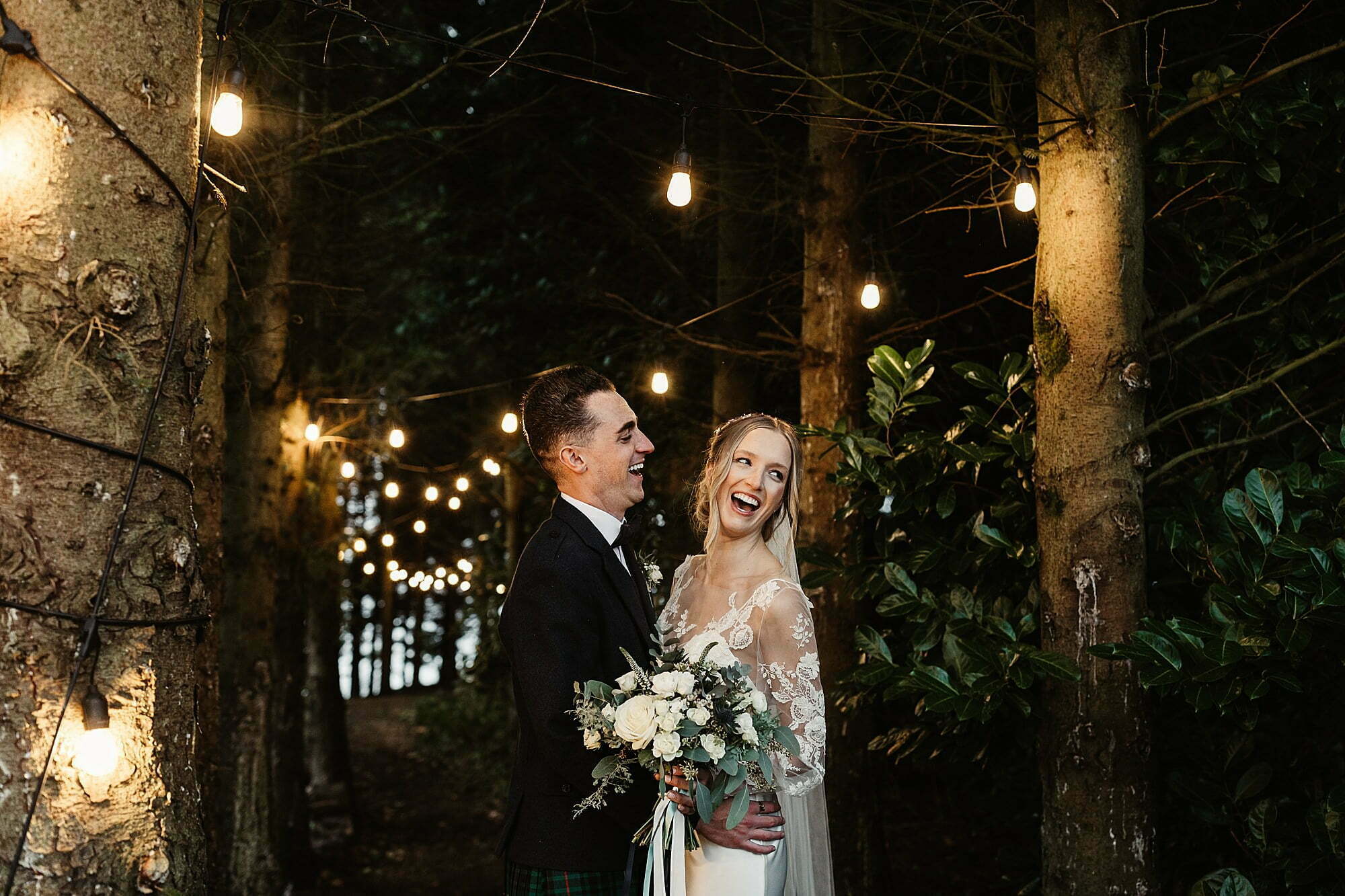 guardswell farm winter wedding woodland festoon lights bride and groom