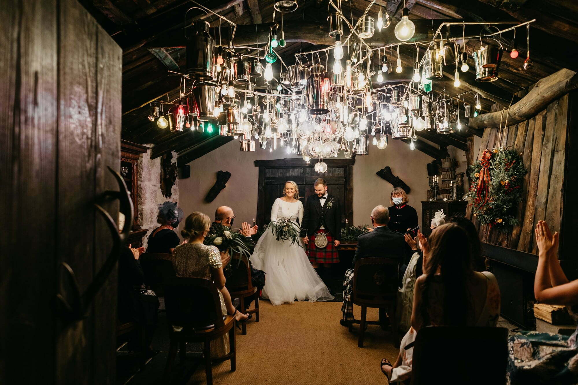 fife arms hotel braemar wedding ceremony room hanging metal light sculpture chandelier leaving the ceremony