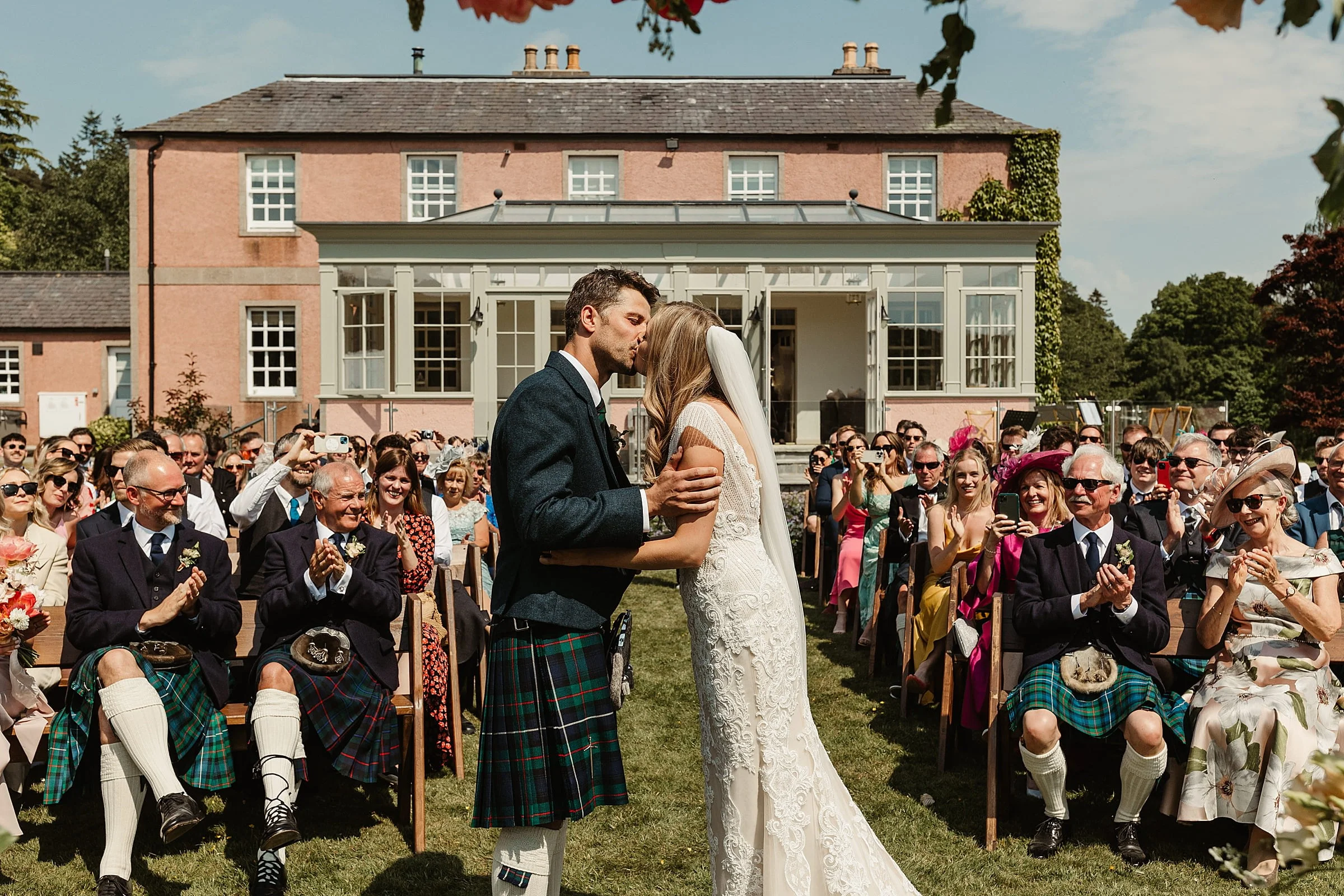 wedding ceremony outside at ballogie house bride and groom first kiss