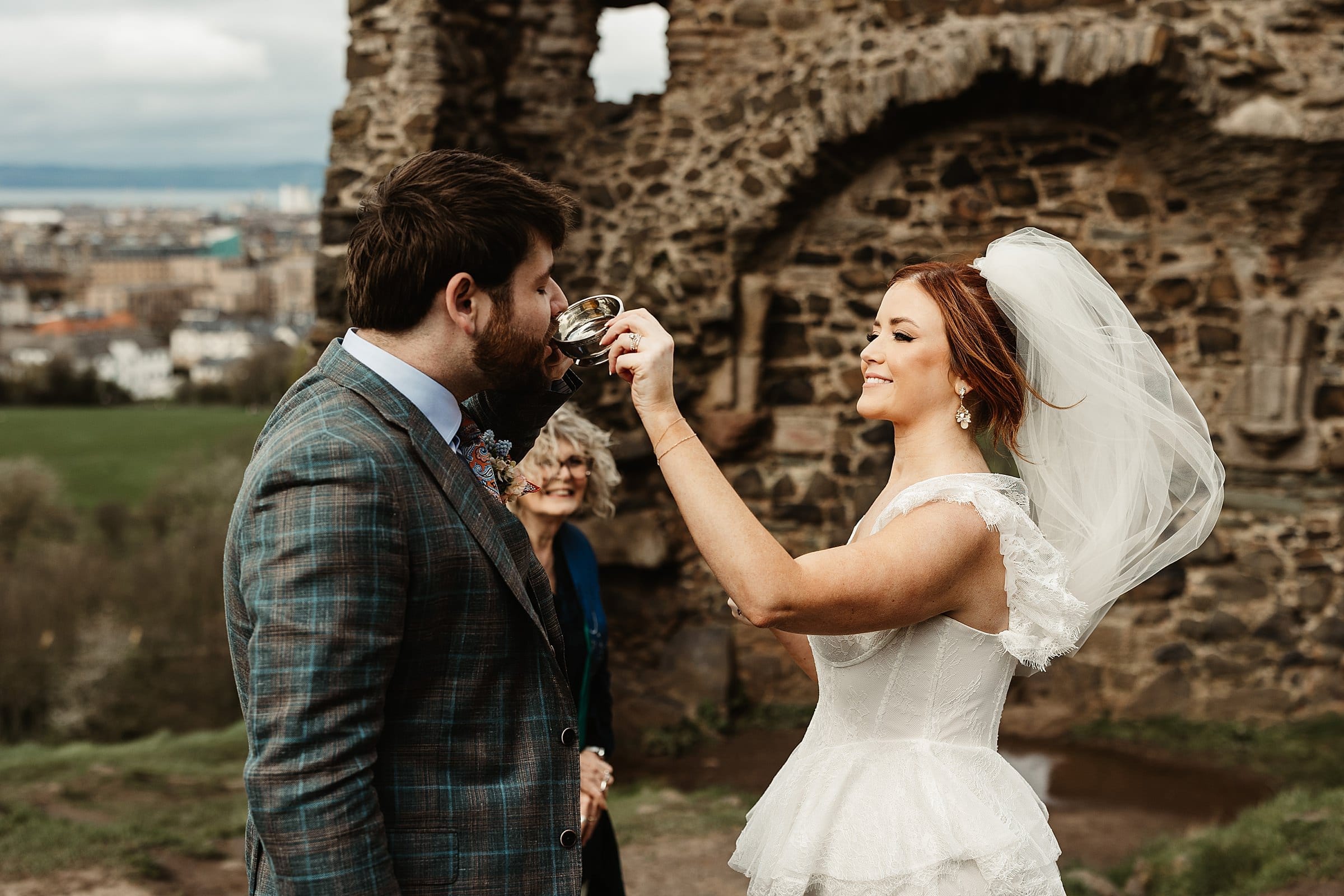 St Anthony's Chapel Ruins elopement wedding photography bride and groom drinking from the quiach