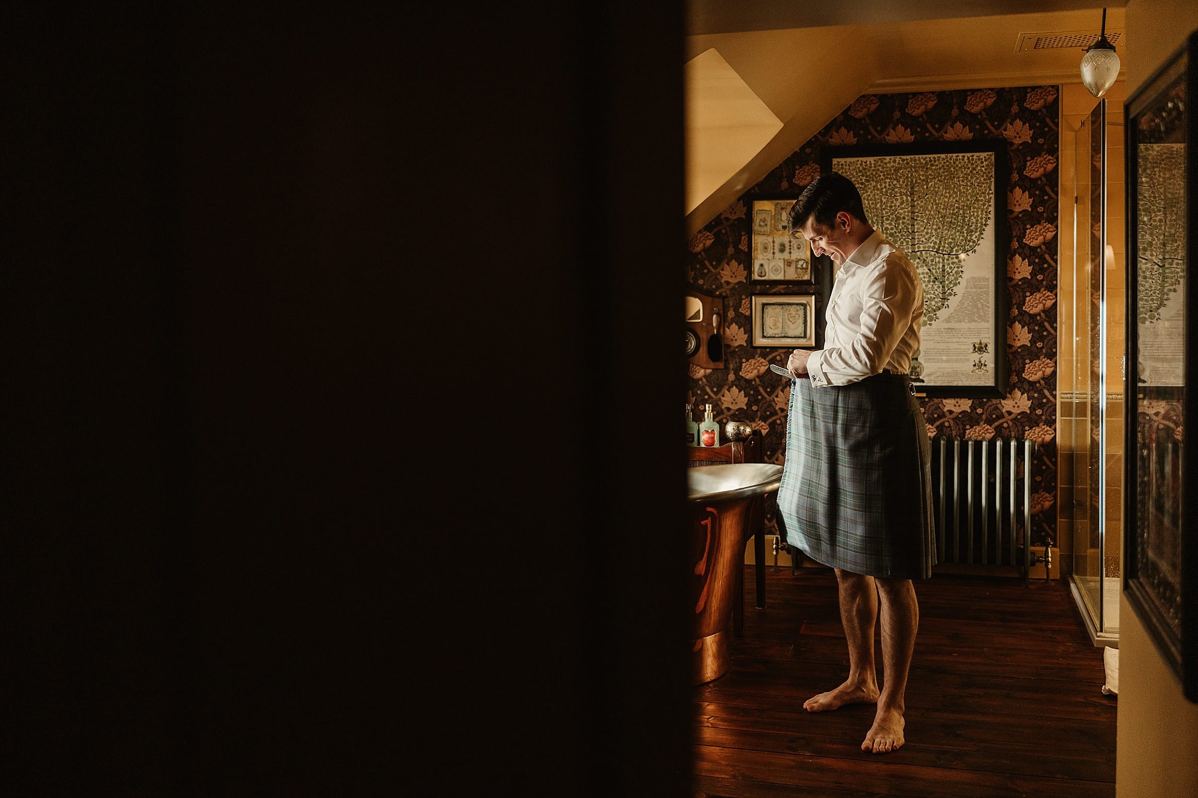 fife arms winter elopement groom getting dressed in a kilt