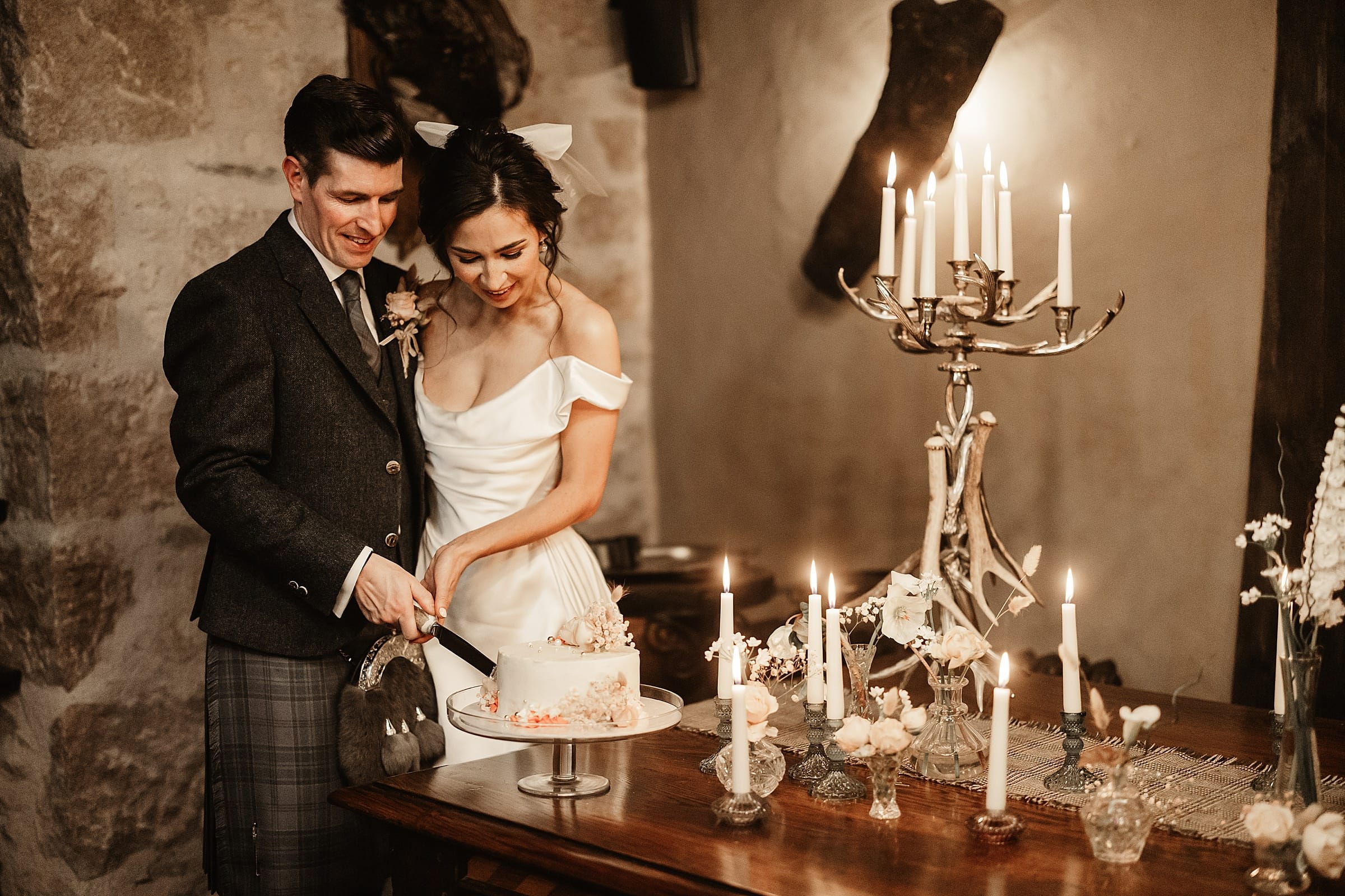 fife arms winter elopement bride and groom cutting cake