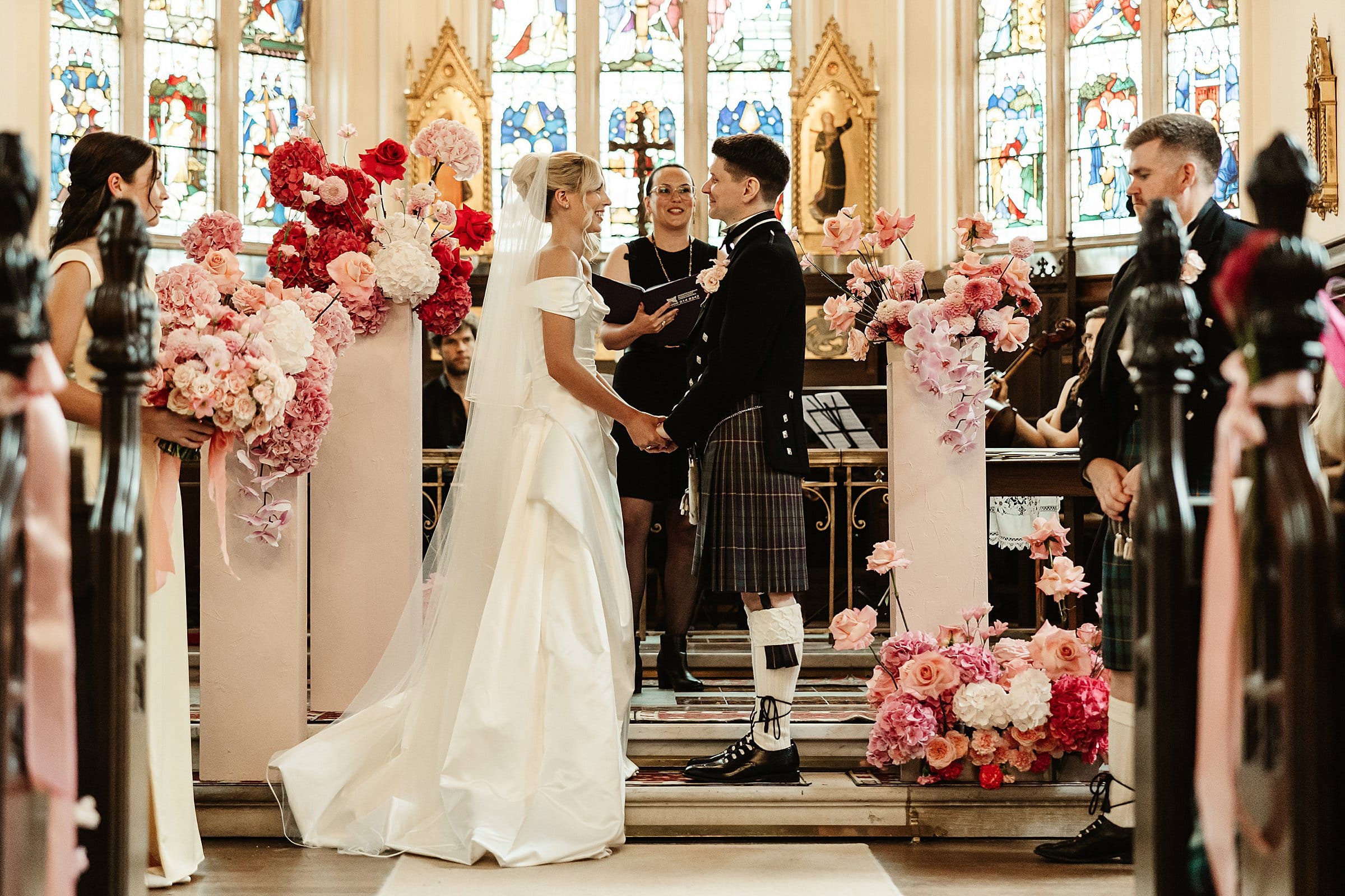 cluny castle wedding ceremony in chapel pink florals and vivienne westwood dress