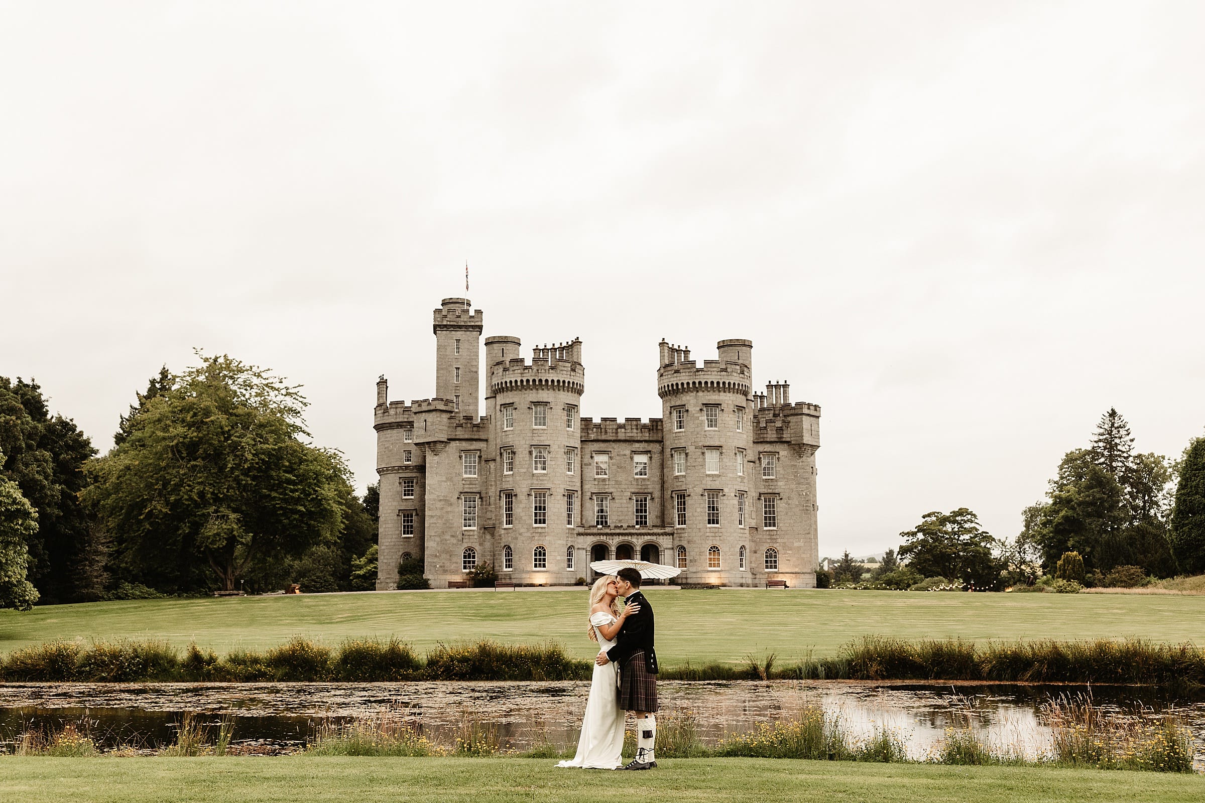 cluny castle wedding photography outdoors bride and groom portraits vivienne westwood dress sun umbrella