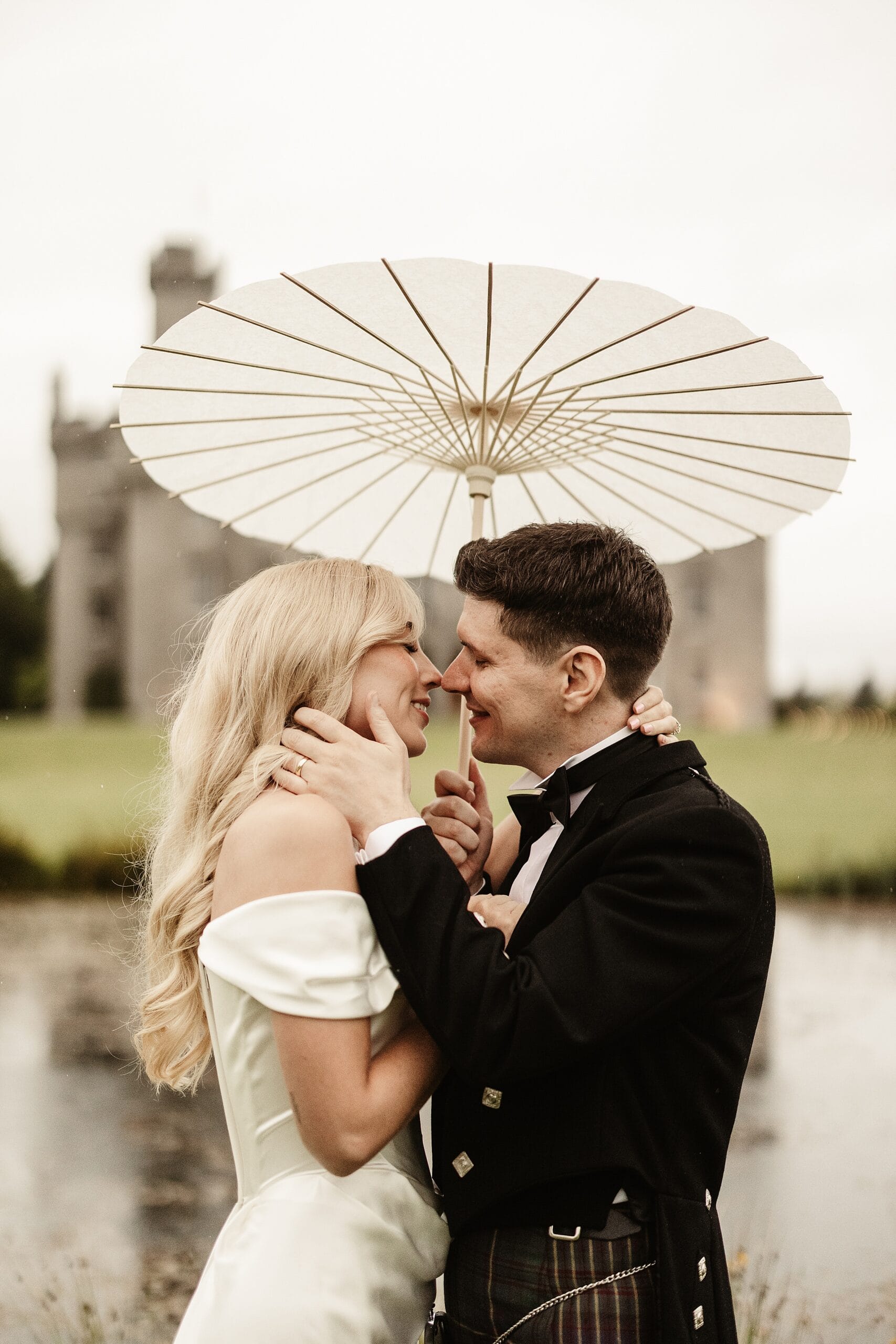 cluny castle wedding photography outdoors bride and groom portraits vivienne westwood dress sun umbrella
