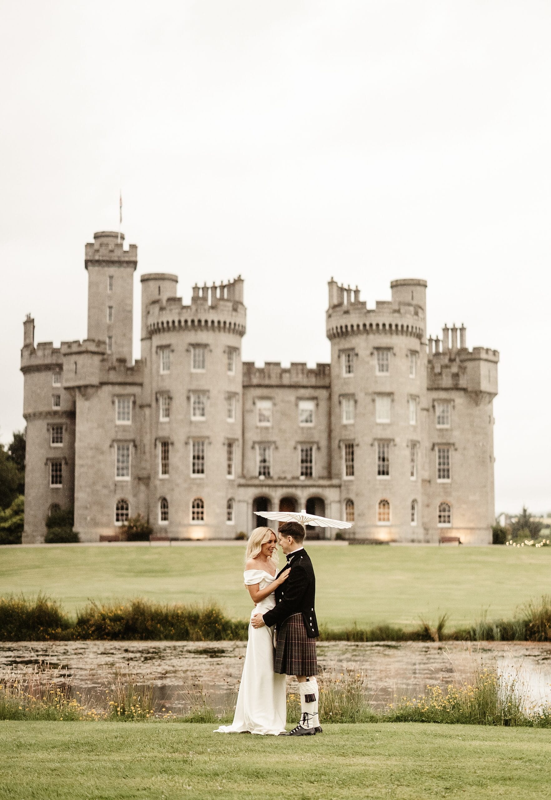 cluny castle wedding photography outdoors bride and groom portraits vivienne westwood dress sun umbrella